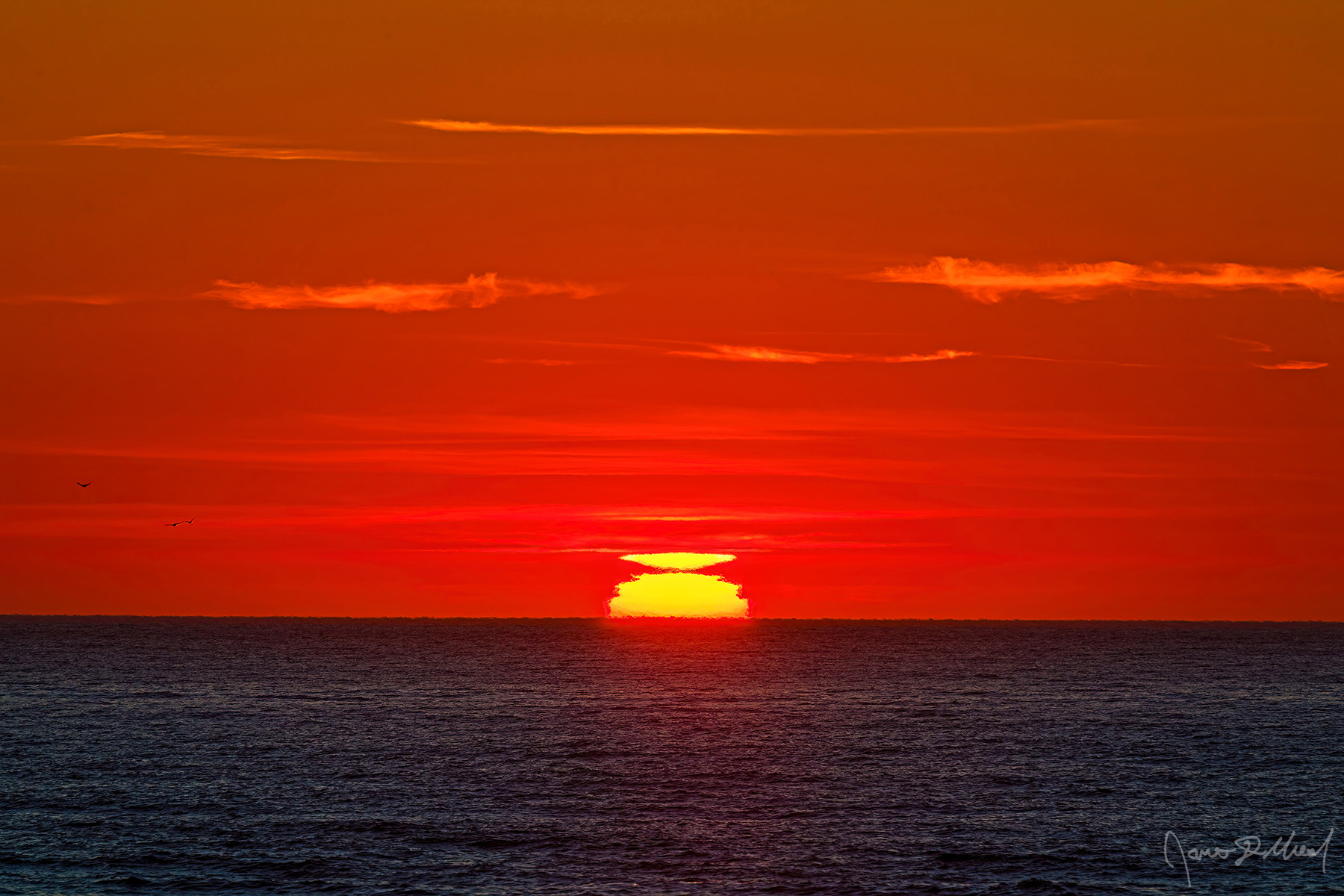 Blaze A mock mirage appears at sunset over the Pacific Ocean along the Oregon Coast as three seagulls fly above the ocean (left side of picture).