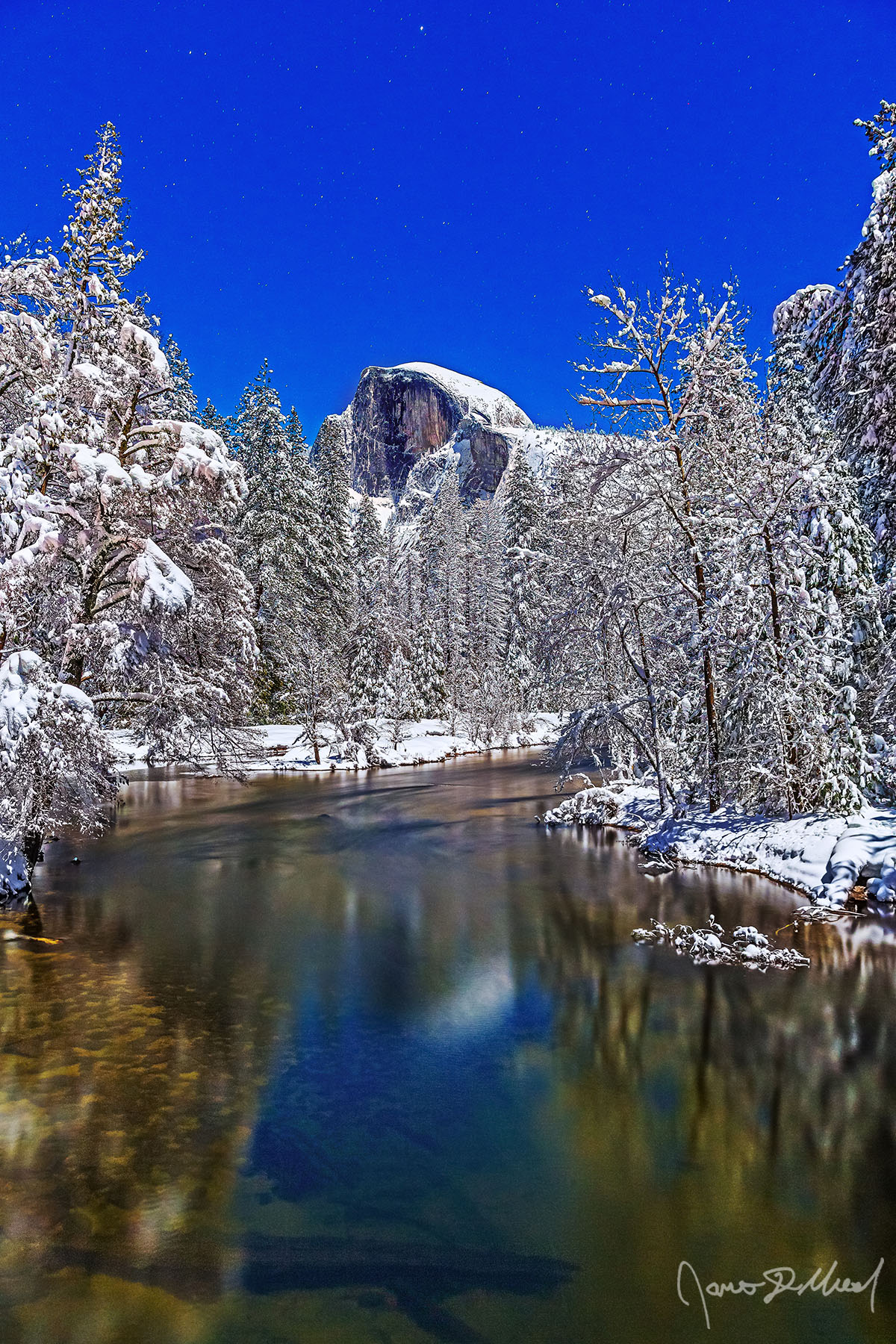 Luminous Tranquility Moonlight illuminates Half Dome as it reflects in the still water of the Merced River. Snow blankets Yosemite Valley and the top of Half Dome as the stars above