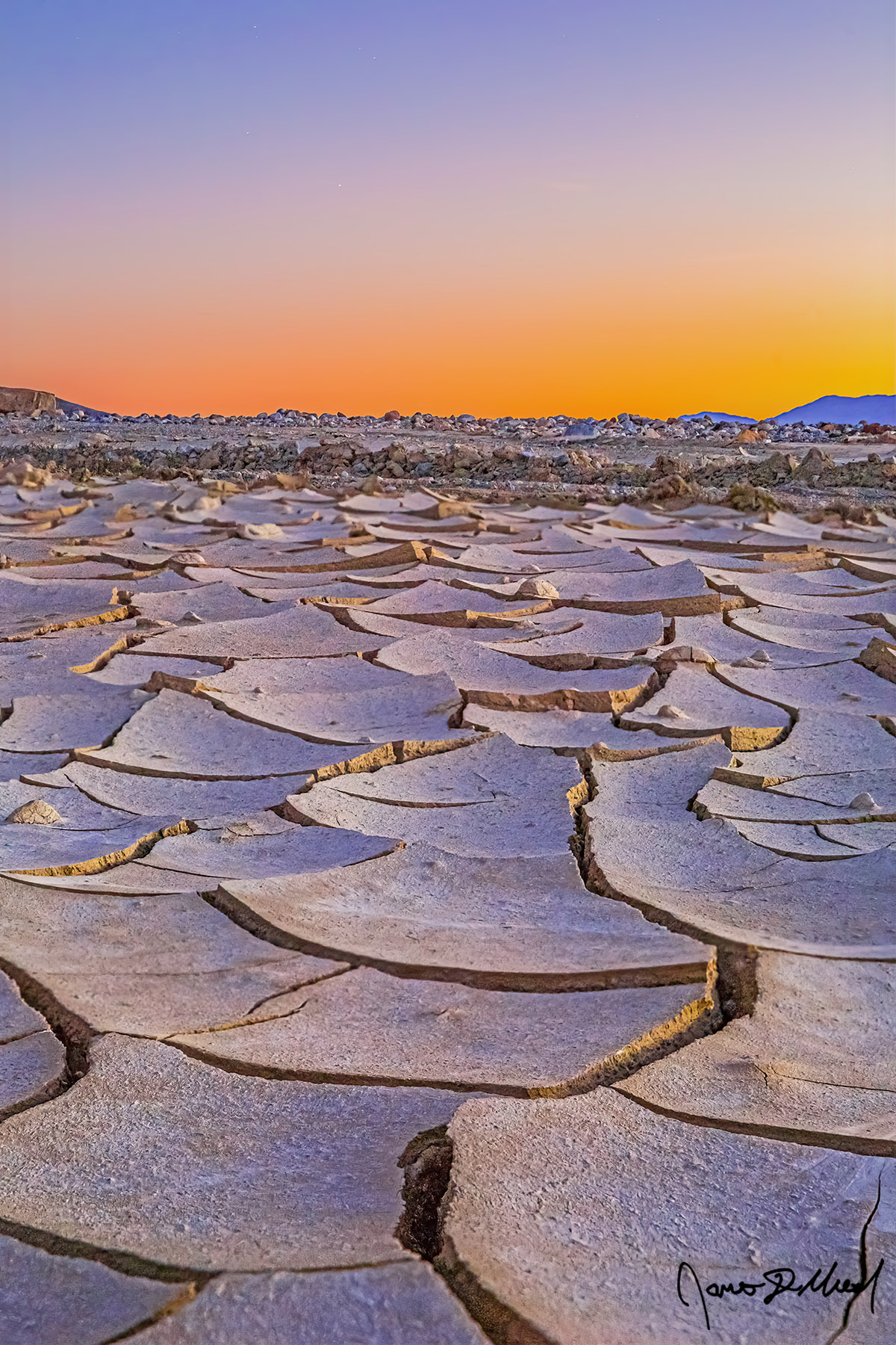 Broken - Nautical Sunset over the Death Valley Mud Cracks and Desert Formations, Death Valley, CA Dried mud in Death Valley creates deep mud cracks shaped like geometric patterns as the last colors from sunset hang on while nautical twilight sets in.