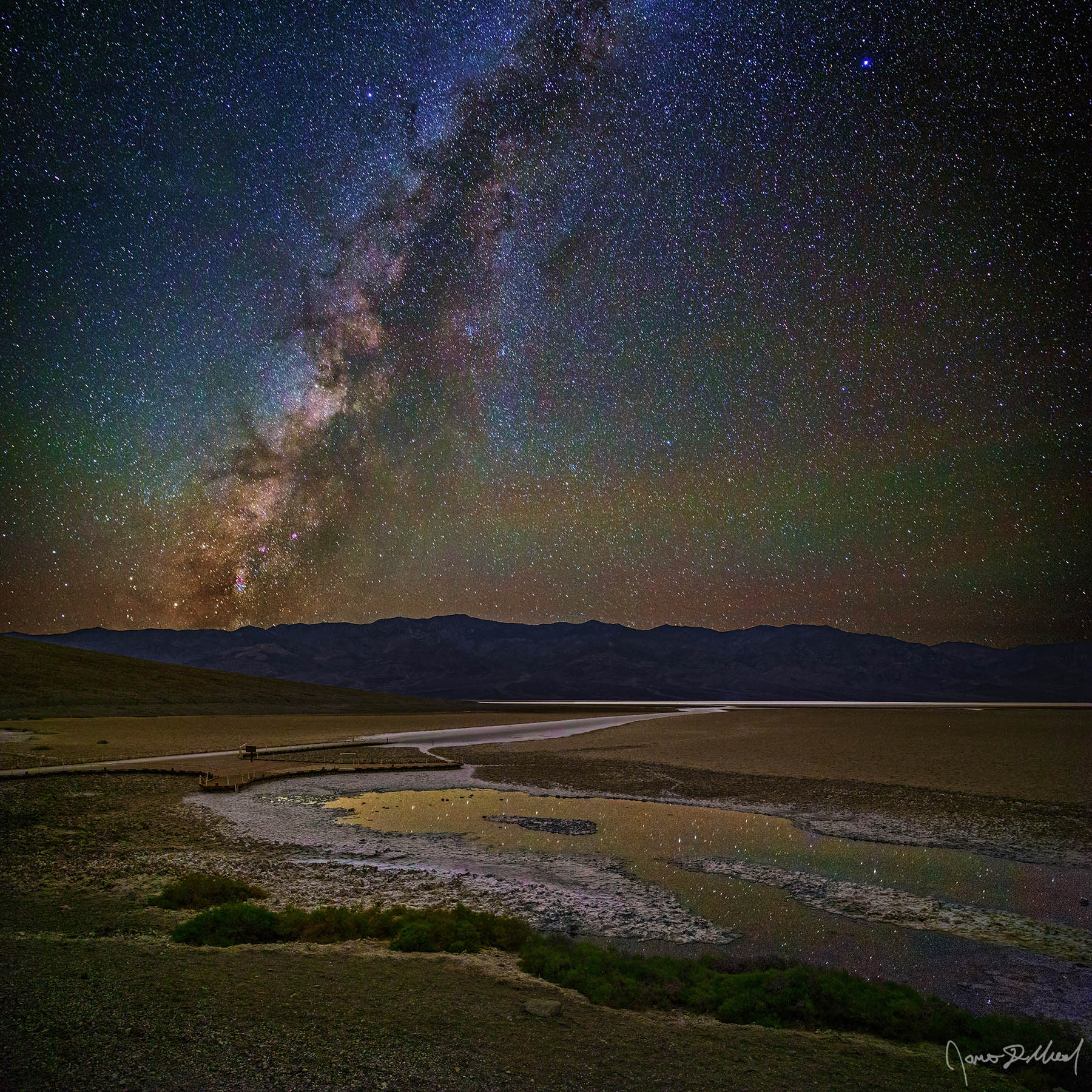 Gleam - Milky Way over Badwater Basin, Badwater Pool and the Panamint Range, Death Valley, CA The Milky Way above Badwater Basin in Death Valley as the stars above reflect in a spring fed pool of water from which Badwater Basin got its name.