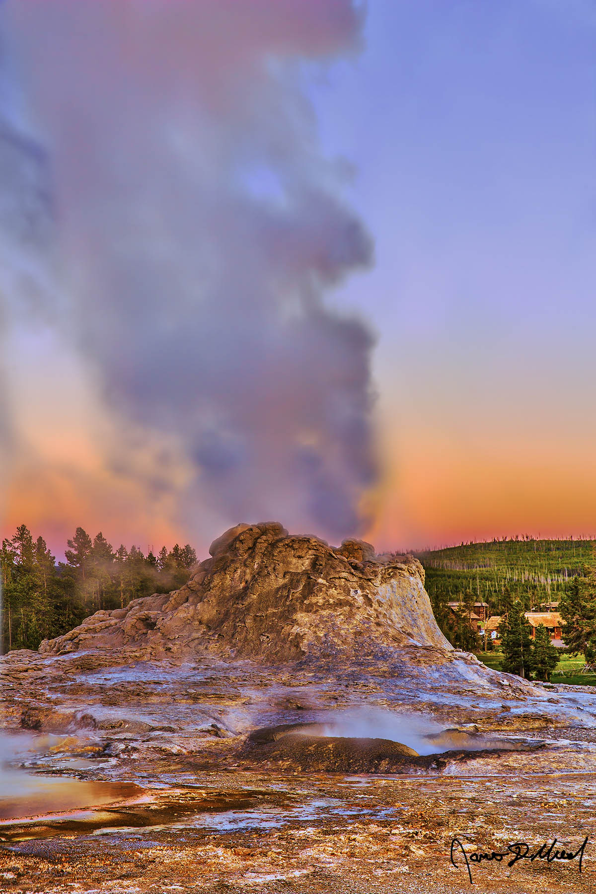 Smoking Fortress Sunset lights the skies behind Castle Geyser in Upper Geyser Basin at sunset, as the light from the setting sun illuminates the water spray from the geyser.