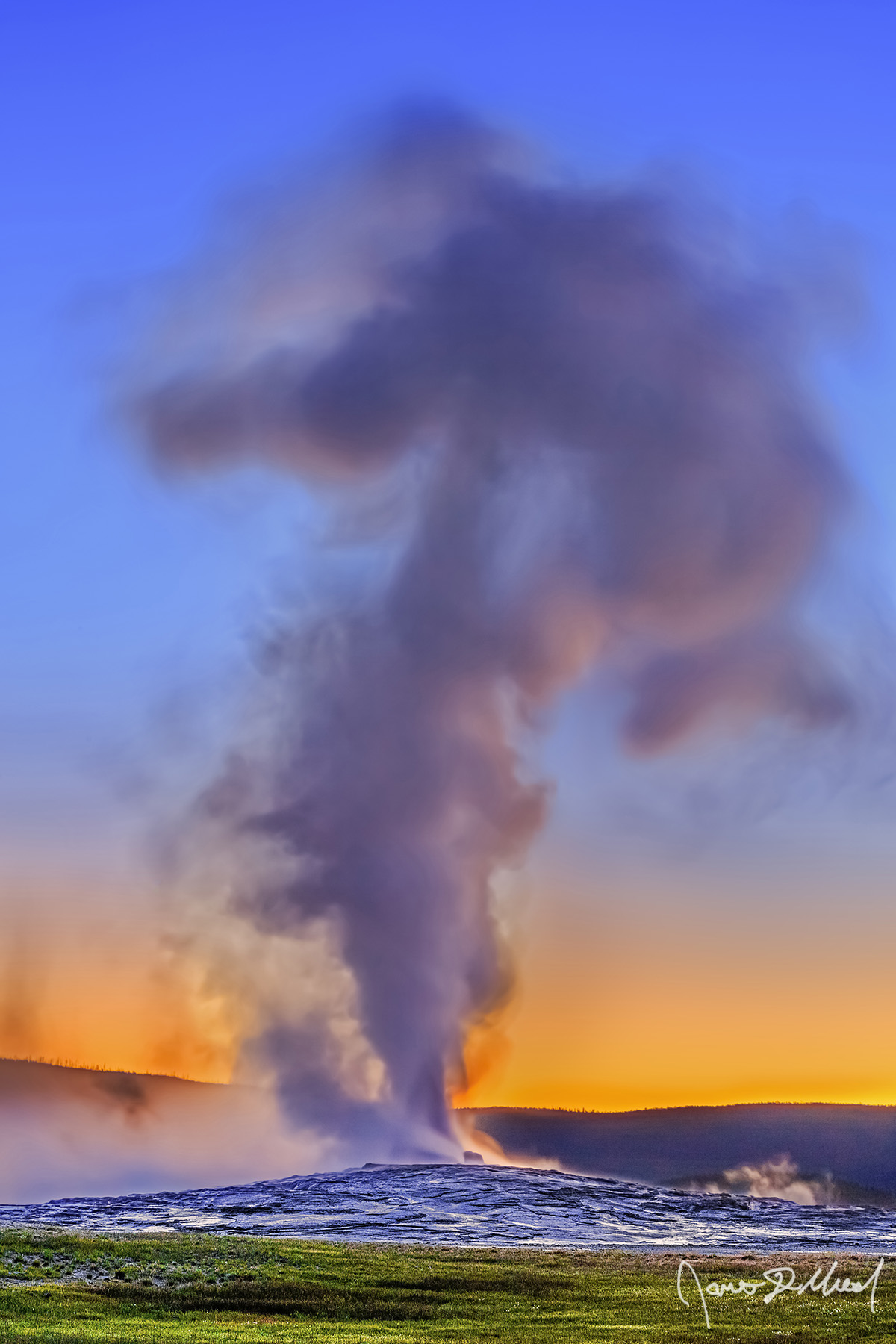 Steam Blast Light from the setting sun reflect off of Old Faithful as it erupts high into the air above Upper Geyser Basin in Yellowstone National Park.