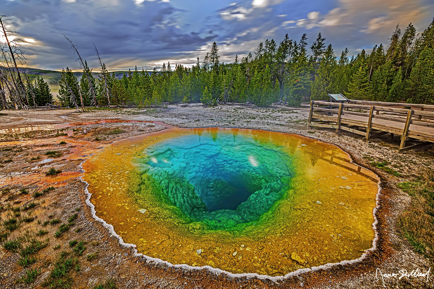 Another Dimension Storms clouds line the skies above at sunset as the orange, emerald and turquoise colored water of Morning Glory Pool reveals its deep chamber.