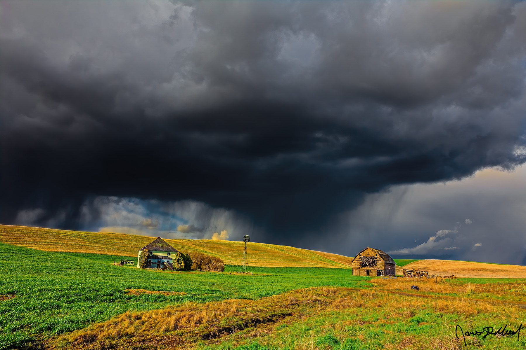 Vengeance A squall line drenches the ridge just above an abandoned farm as sunshine peaks through a break in the storm clouds in the Palouse of Eastern, Washington